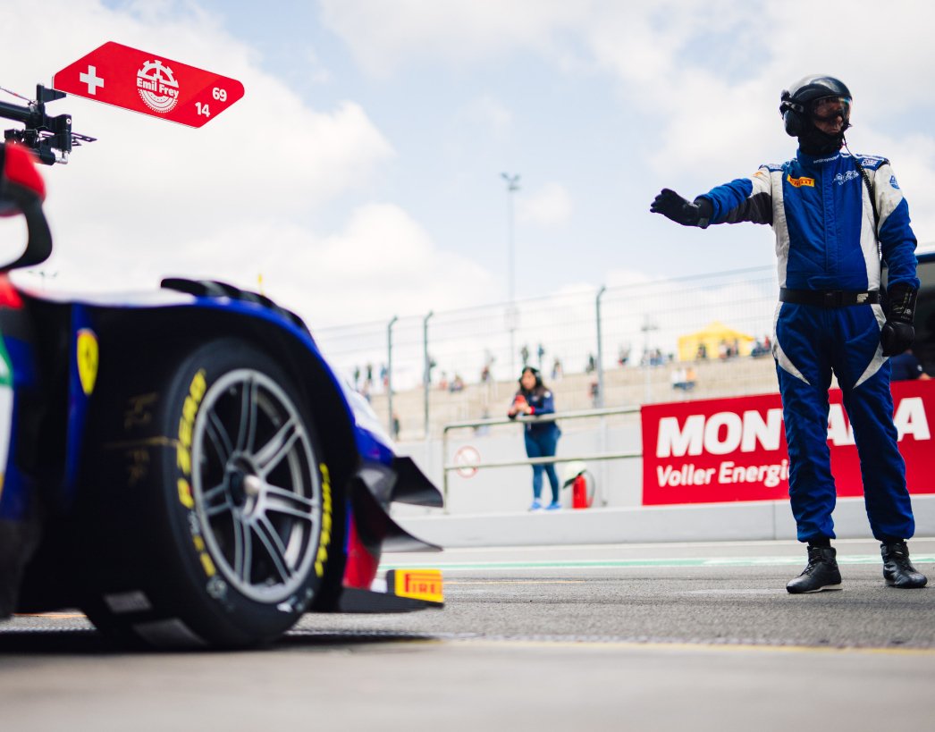 Mechaniker zeigt dem Fahrer ein Wartezeichen